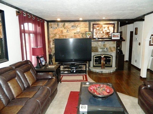 living room with a fireplace, hardwood / wood-style floors, and a textured ceiling