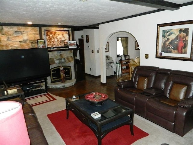 living room featuring a fireplace, beam ceiling, a textured ceiling, and carpet