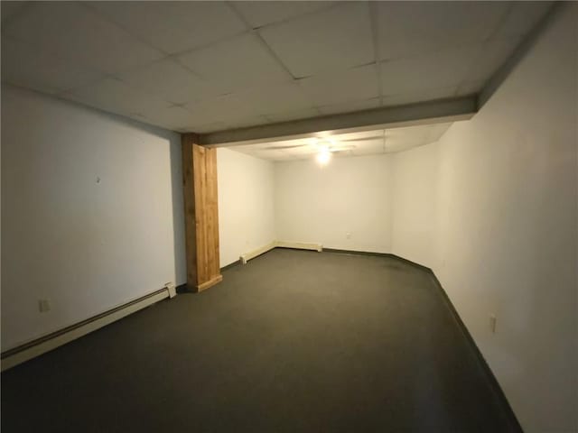 basement featuring a baseboard heating unit and a paneled ceiling