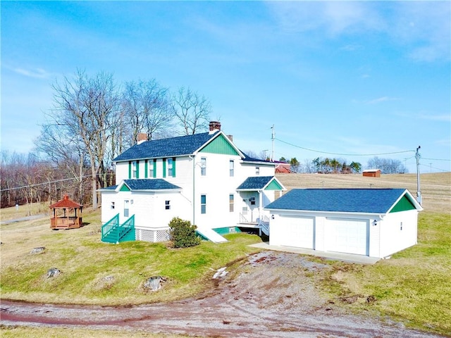 exterior space with a gazebo, a garage, and a front lawn