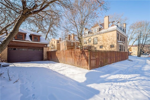 view of snowy exterior featuring a garage