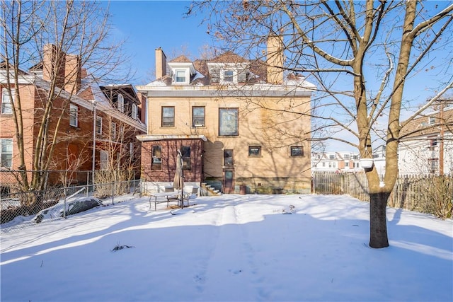 view of snow covered back of property