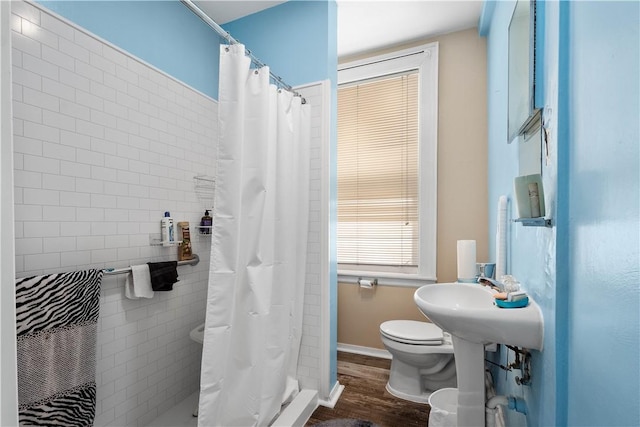 bathroom featuring wood-type flooring, toilet, and walk in shower