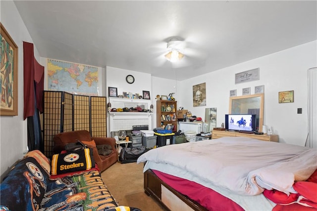 bedroom featuring ceiling fan, a brick fireplace, and light carpet