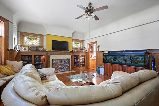 living room with hardwood / wood-style flooring, ceiling fan, a healthy amount of sunlight, and a high end fireplace