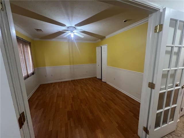 spare room featuring crown molding, a textured ceiling, ceiling fan, and hardwood / wood-style flooring