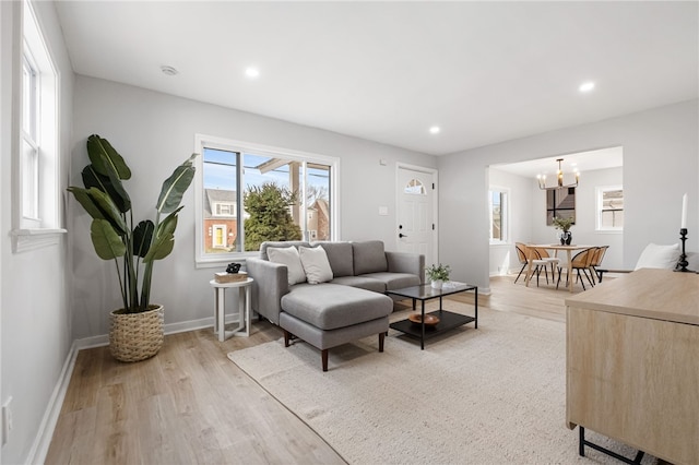 living room with a notable chandelier and light wood-type flooring