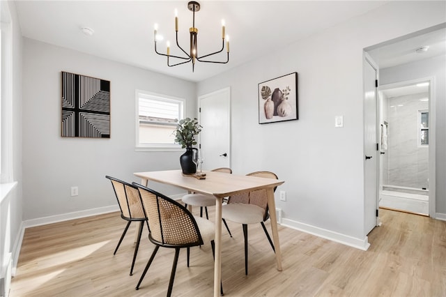 dining space featuring a notable chandelier and light wood-type flooring