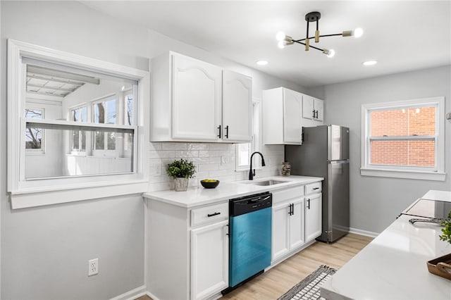 kitchen featuring sink, white cabinetry, tasteful backsplash, light hardwood / wood-style flooring, and stainless steel appliances