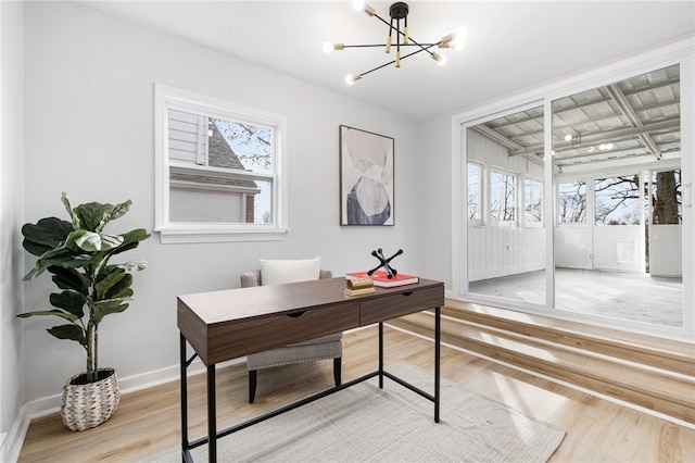 office featuring an inviting chandelier and light hardwood / wood-style flooring