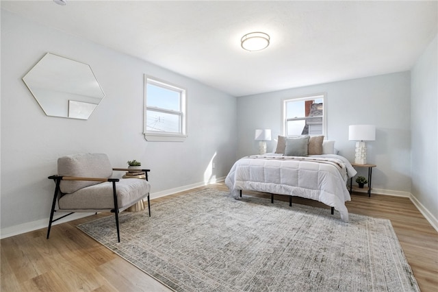 bedroom featuring multiple windows and light hardwood / wood-style flooring