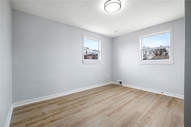 spare room featuring plenty of natural light and light hardwood / wood-style floors