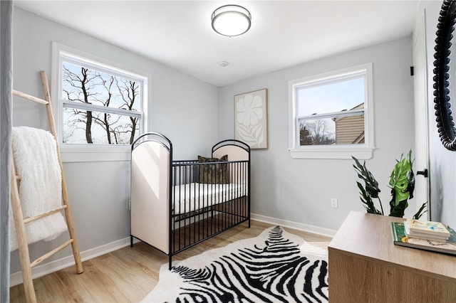 bedroom featuring multiple windows and light hardwood / wood-style flooring