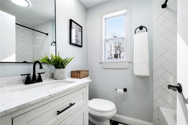 full bathroom featuring vanity, tiled shower / bath, and toilet