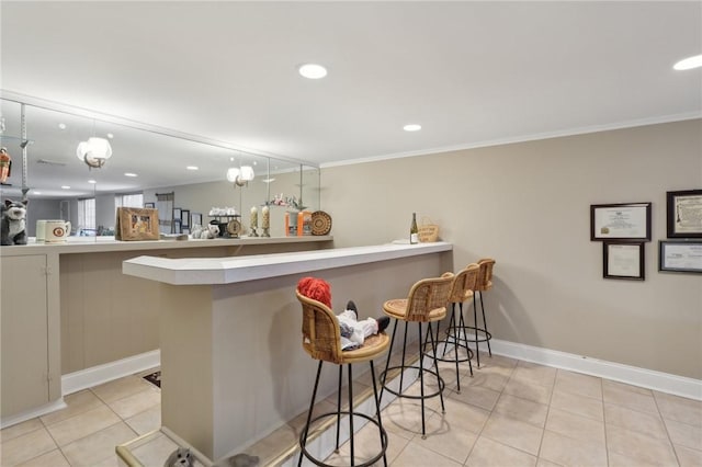 kitchen featuring a breakfast bar, crown molding, decorative light fixtures, light tile patterned floors, and kitchen peninsula