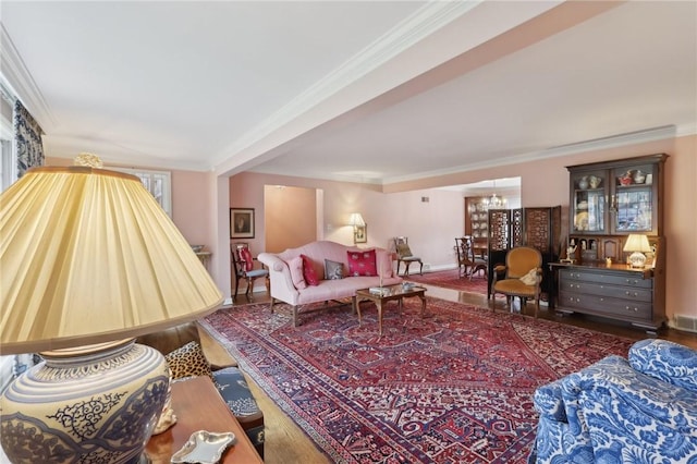 living room featuring crown molding, dark hardwood / wood-style flooring, and a chandelier