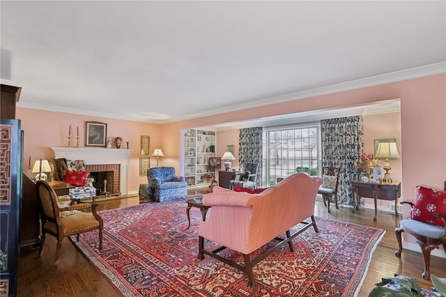 living room featuring hardwood / wood-style floors, ornamental molding, and a brick fireplace