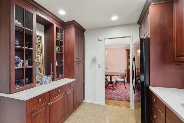 interior space with black fridge and light stone counters