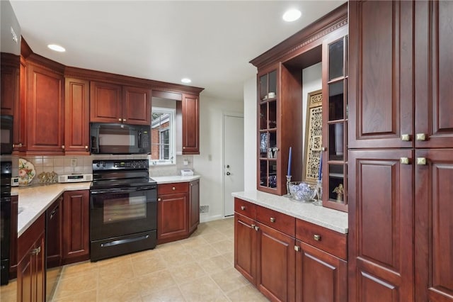 kitchen featuring tasteful backsplash, light stone countertops, and black appliances