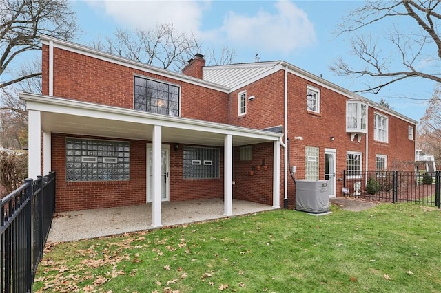 back of house with a lawn and a patio area