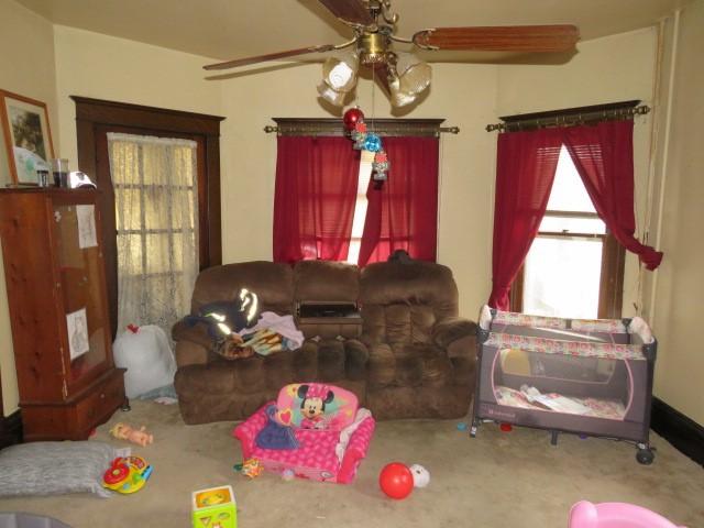 carpeted living room featuring ceiling fan