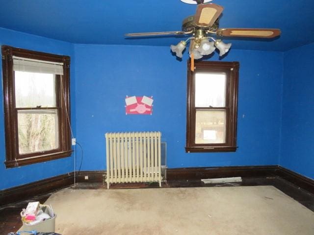 spare room featuring ceiling fan and radiator