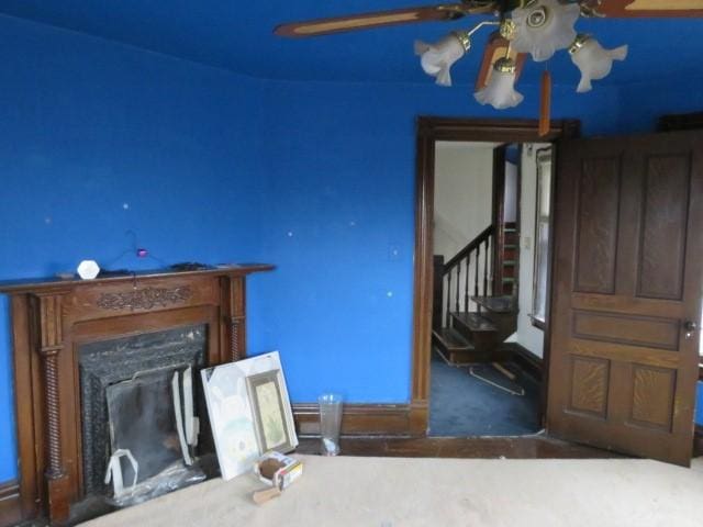 unfurnished living room featuring exterior fireplace and ceiling fan