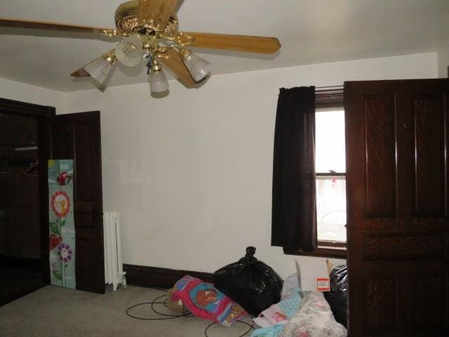 bedroom with radiator heating unit, ceiling fan, and carpet flooring