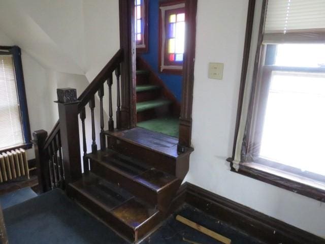 staircase with lofted ceiling and radiator heating unit