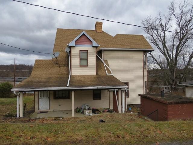 rear view of house featuring a lawn and a patio area