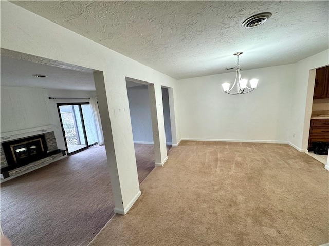 unfurnished dining area with carpet flooring, a notable chandelier, and a textured ceiling