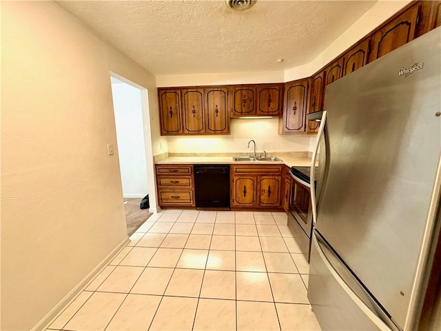 kitchen featuring light tile patterned flooring, appliances with stainless steel finishes, sink, and a textured ceiling