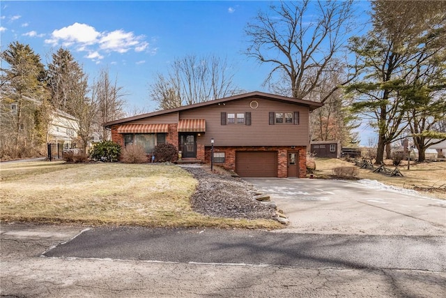 split level home featuring a garage and a front lawn