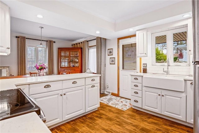 kitchen featuring pendant lighting, white cabinetry, and sink