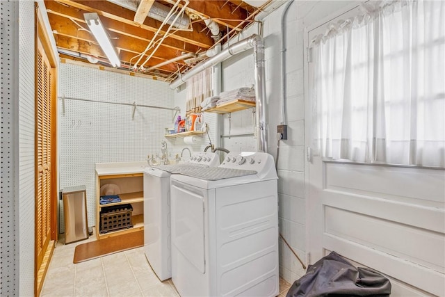 laundry area with light tile patterned flooring and washing machine and dryer