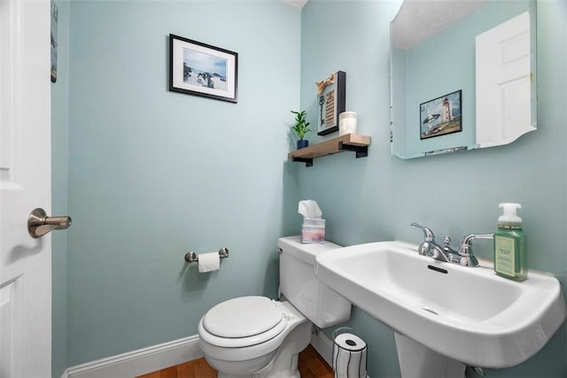 bathroom with hardwood / wood-style flooring, sink, and toilet