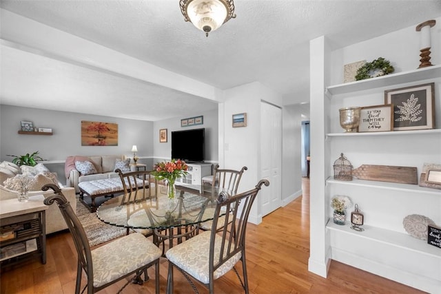 dining area with hardwood / wood-style flooring and a textured ceiling