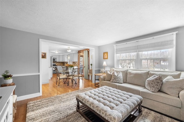 living room with a textured ceiling and light hardwood / wood-style flooring