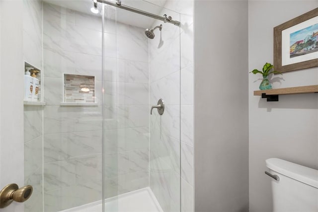 bathroom featuring toilet and a shower with door