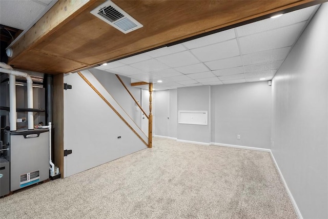 basement featuring carpet floors and a paneled ceiling