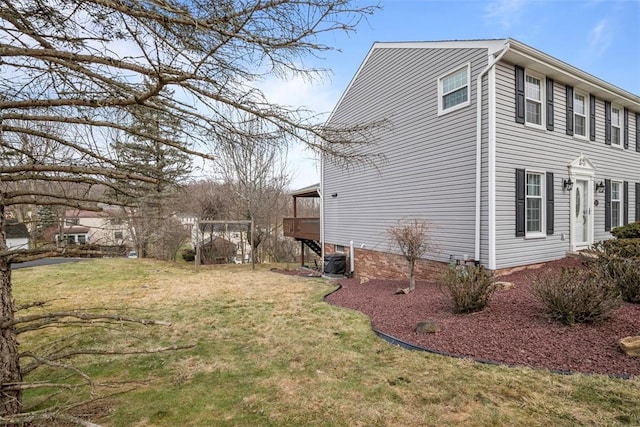 view of property exterior with a yard and a deck