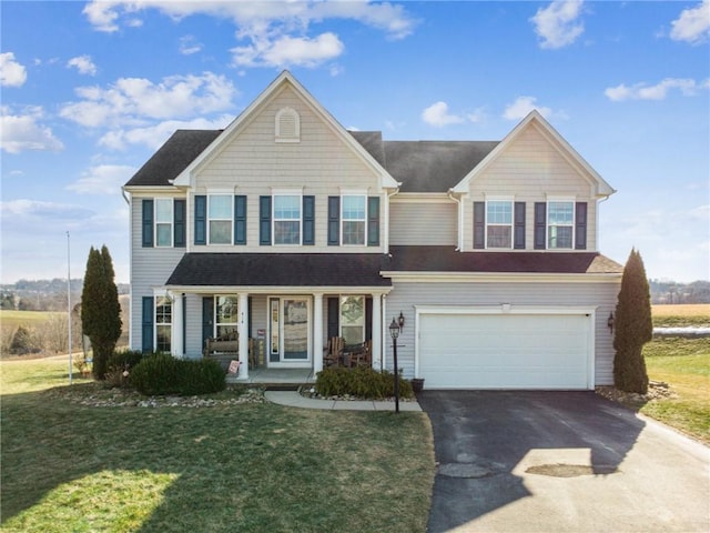 view of front of house featuring a garage, a front yard, and covered porch