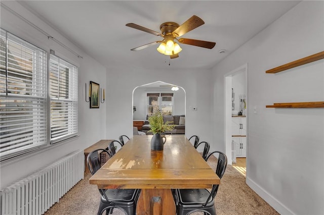 dining room with radiator, light colored carpet, and ceiling fan