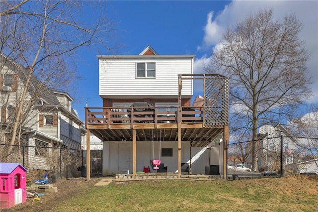 rear view of house with a deck and a lawn