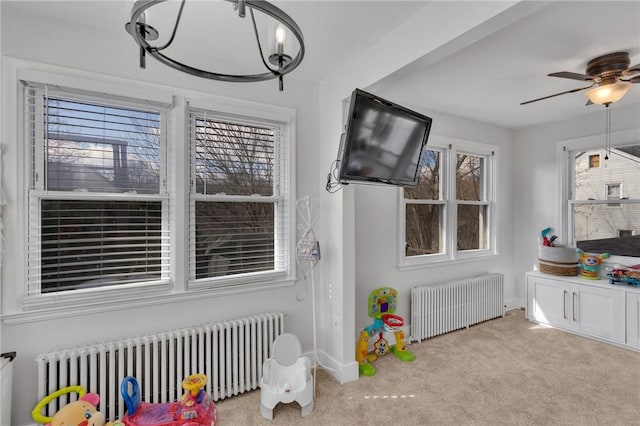 rec room with light carpet, radiator, and ceiling fan