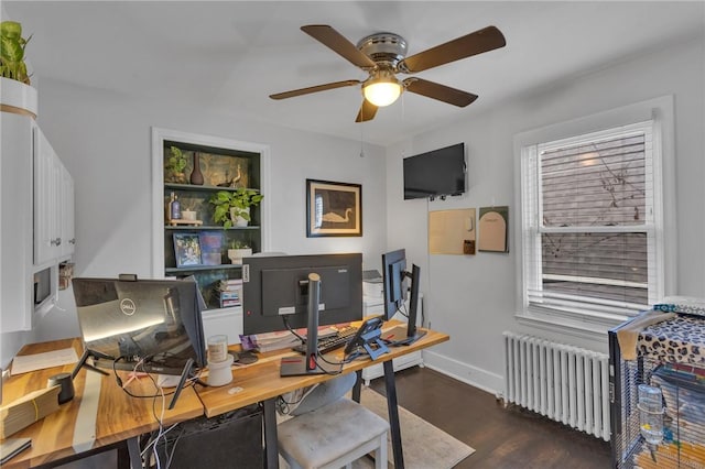 office featuring dark wood-type flooring, ceiling fan, and radiator