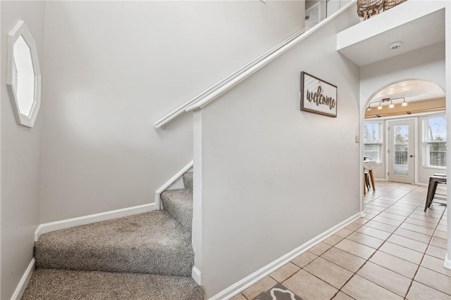 530 Peregrine Dr, North Huntingdon, PA 15642 - stairway with tile patterned floors, baseboards, arched walkways, and track lighting