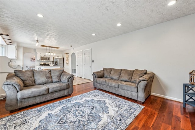 530 Peregrine Dr, North Huntingdon, PA 15642 - living area with arched walkways, a textured ceiling, and hardwood / wood-style flooring
