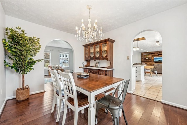 530 Peregrine Dr, North Huntingdon, PA 15642 - dining space featuring hardwood / wood-style flooring, a notable chandelier, arched walkways, and a textured ceiling