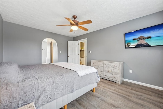 530 Peregrine Dr, North Huntingdon, PA 15642 - bedroom featuring wood finished floors, baseboards, arched walkways, ceiling fan, and a textured ceiling